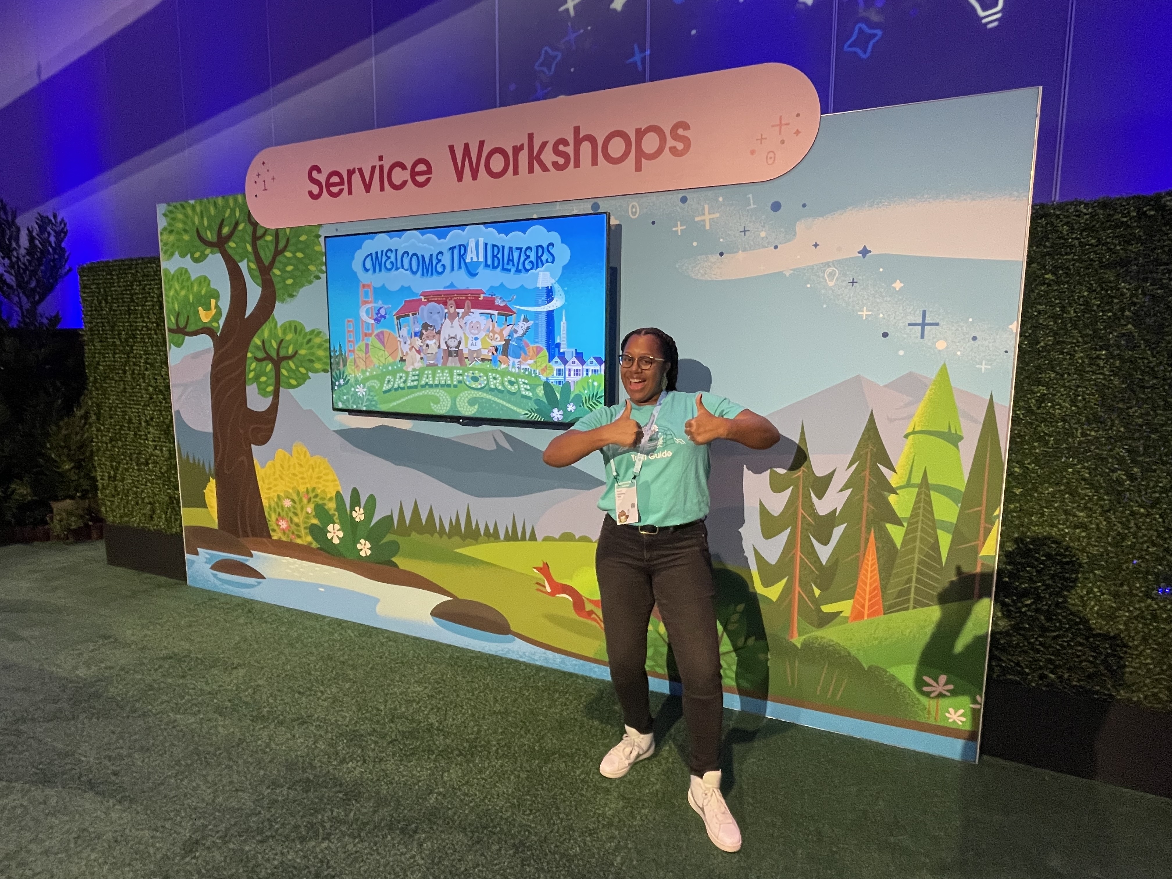Tamara at Dreamforce, pointing to a 'Welcome Trailblazers' screen